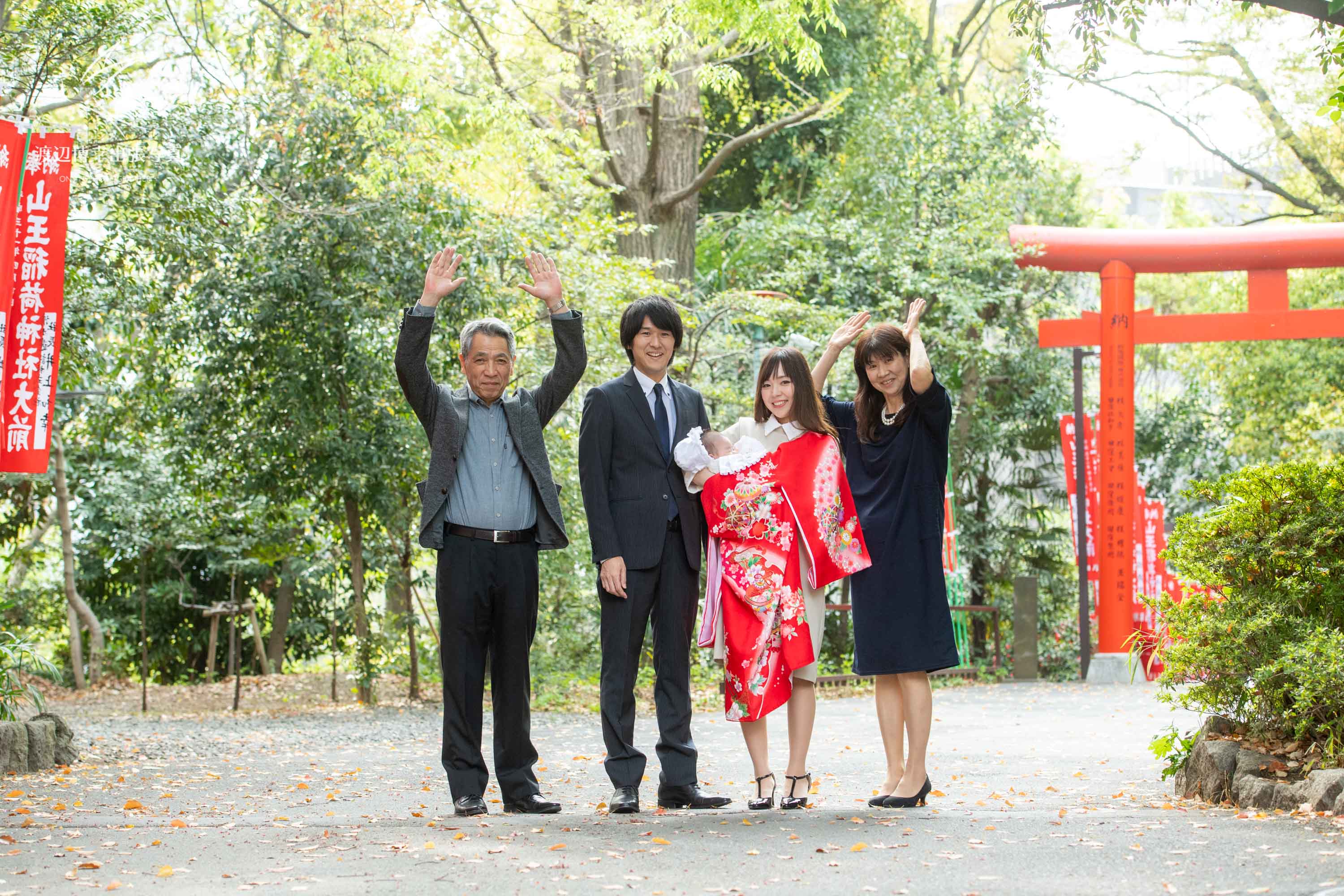 赤坂の日枝神社でお宮参りのバンザイをしている4人の集合写真