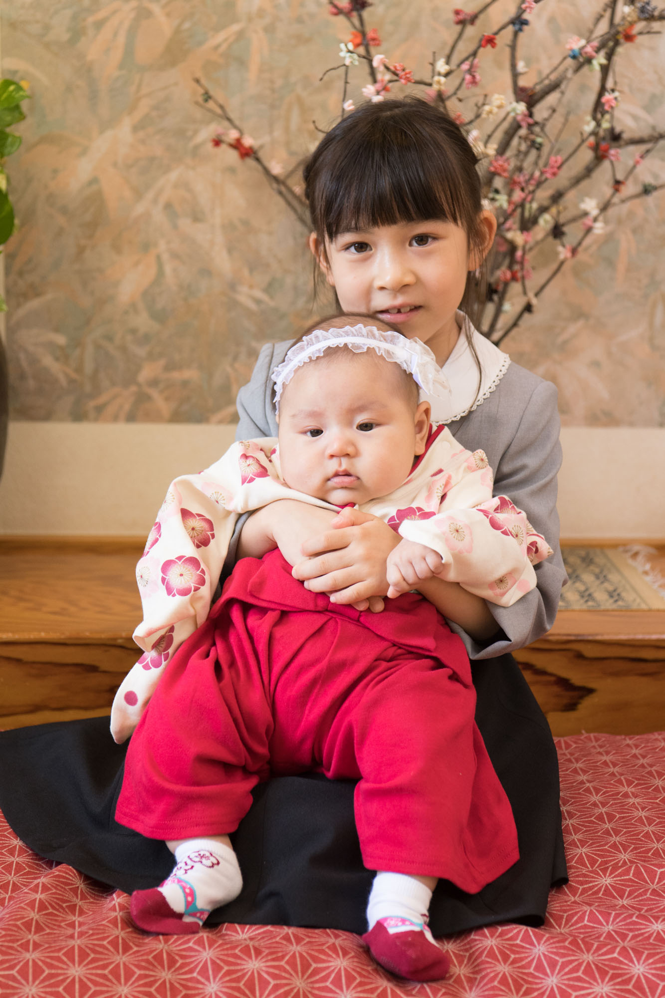 画像 大村庵の座敷でお宮参りの赤ちゃんを抱っこして微笑む。7歳位の女の子。