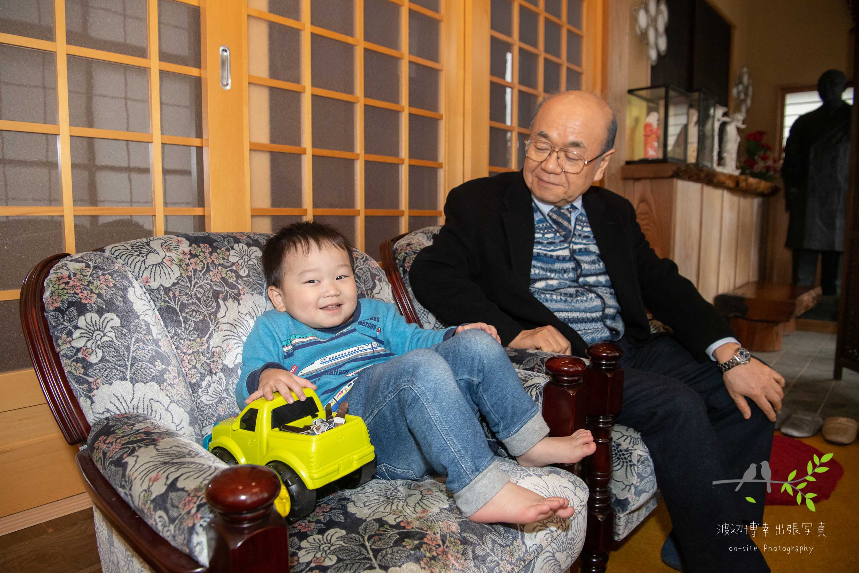 椅子に座る男の子と祖父