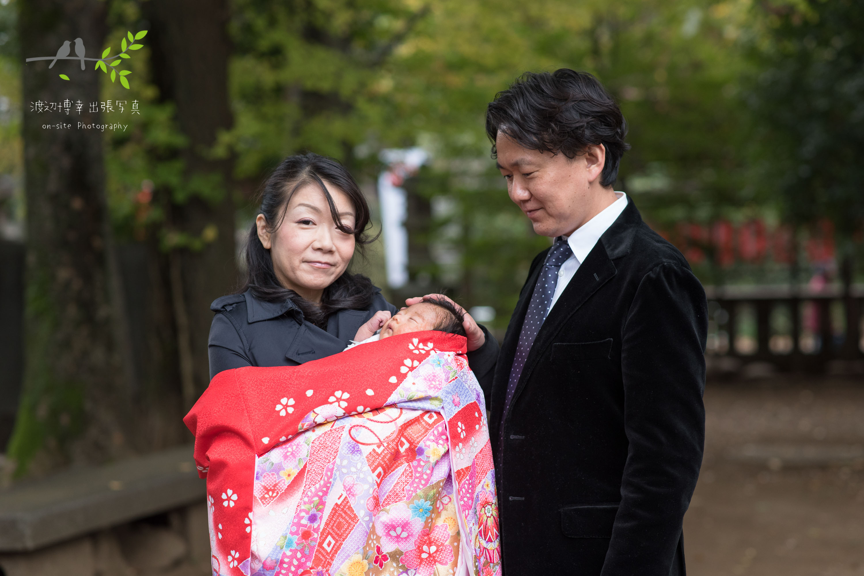 お宮参りの掛着姿で赤ちゃんを抱く母親と父親
