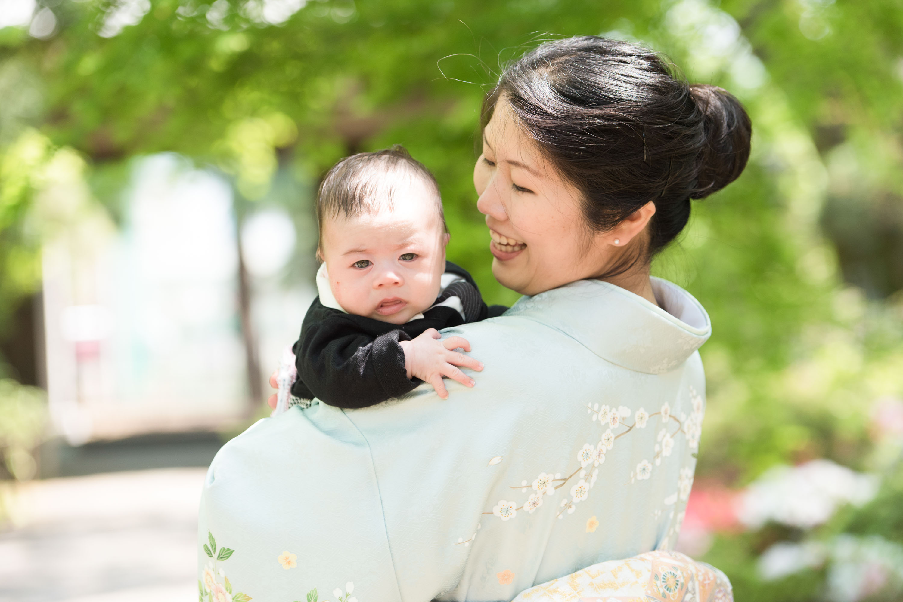 お宮参りの赤ちゃんを抱く和服姿の女性の画像