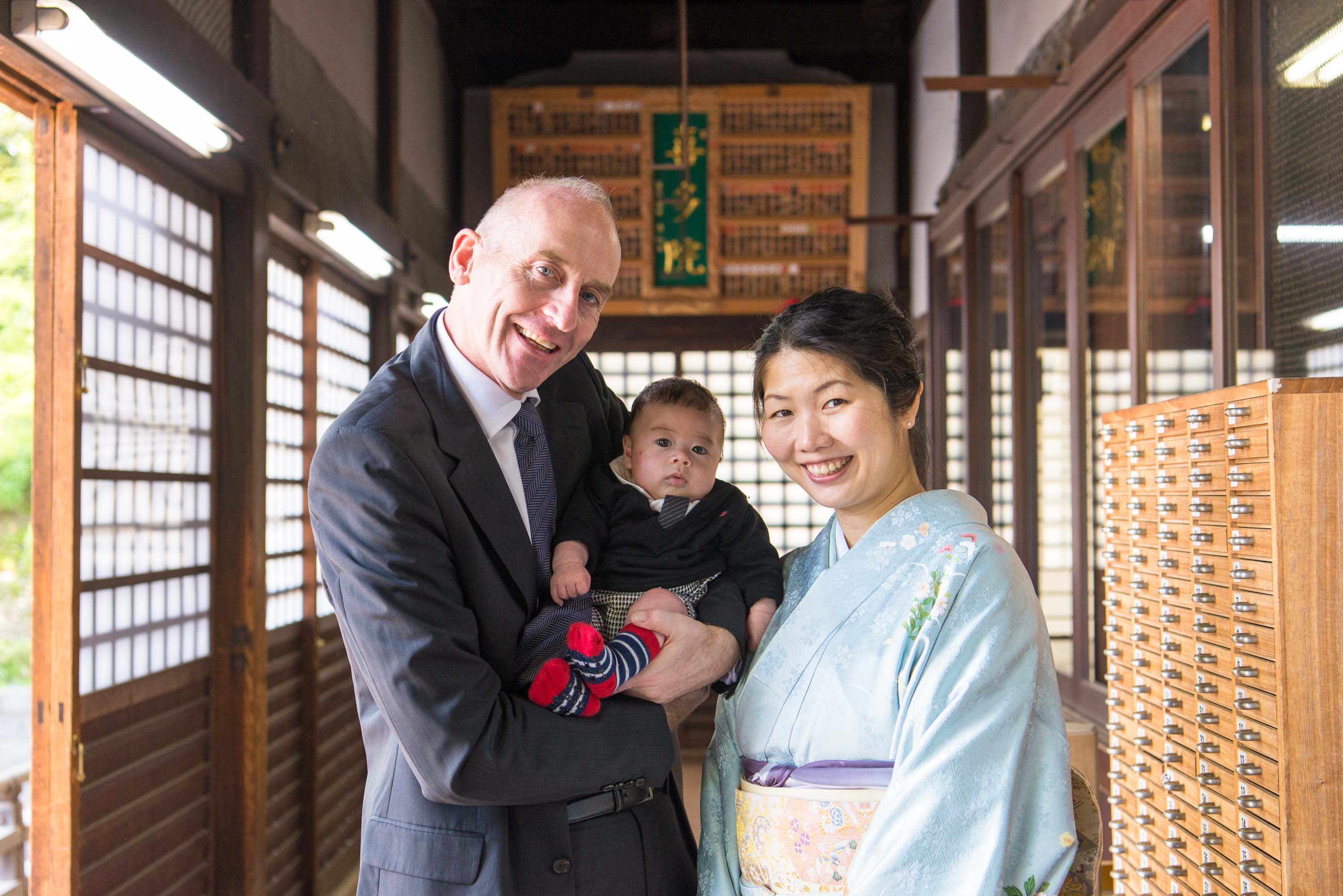 喜多院本殿の中に立つ赤ちゃんを抱いた男性と横に立つ女性の画像