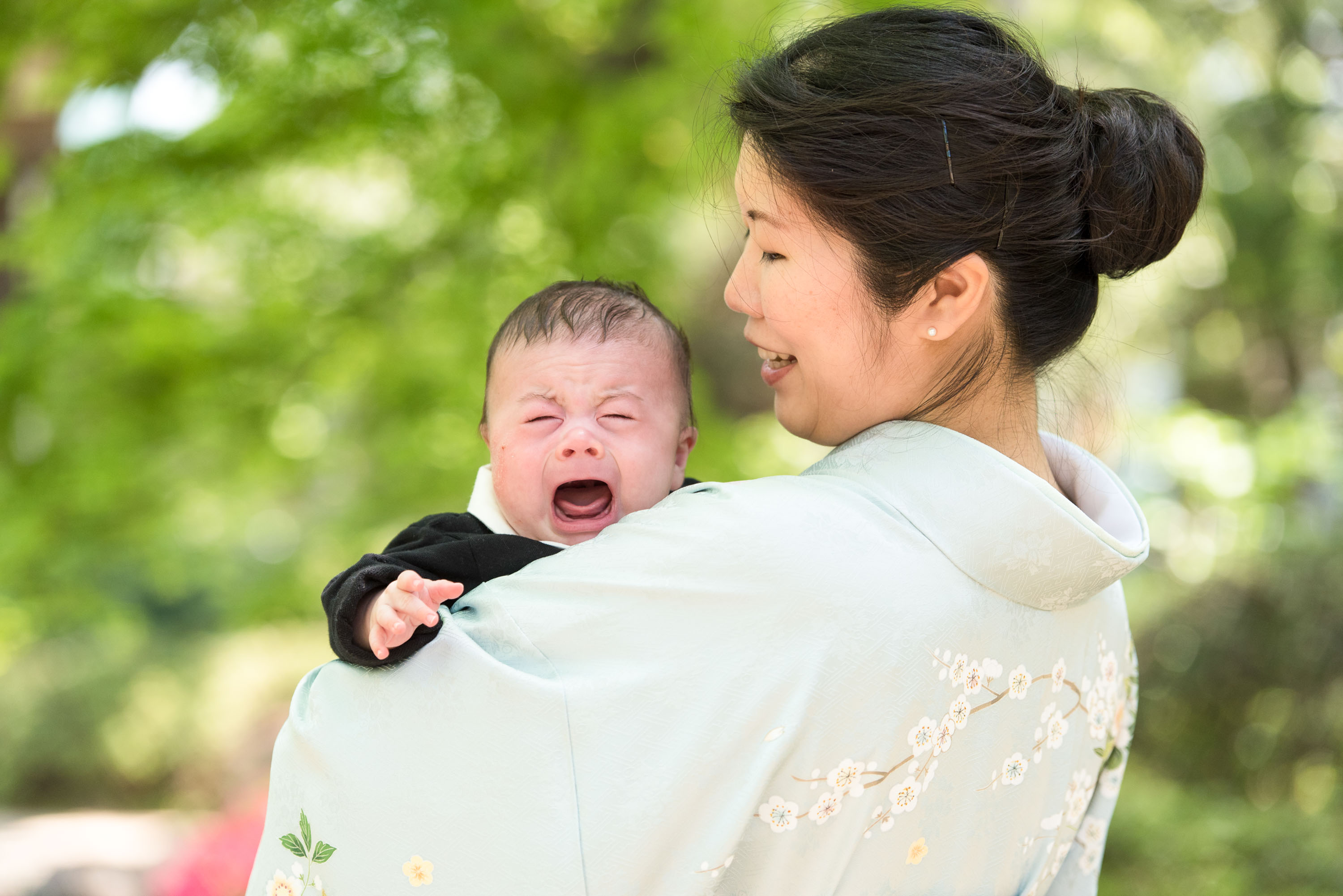 泣いている赤ちゃんを抱く和服姿の女性の画像