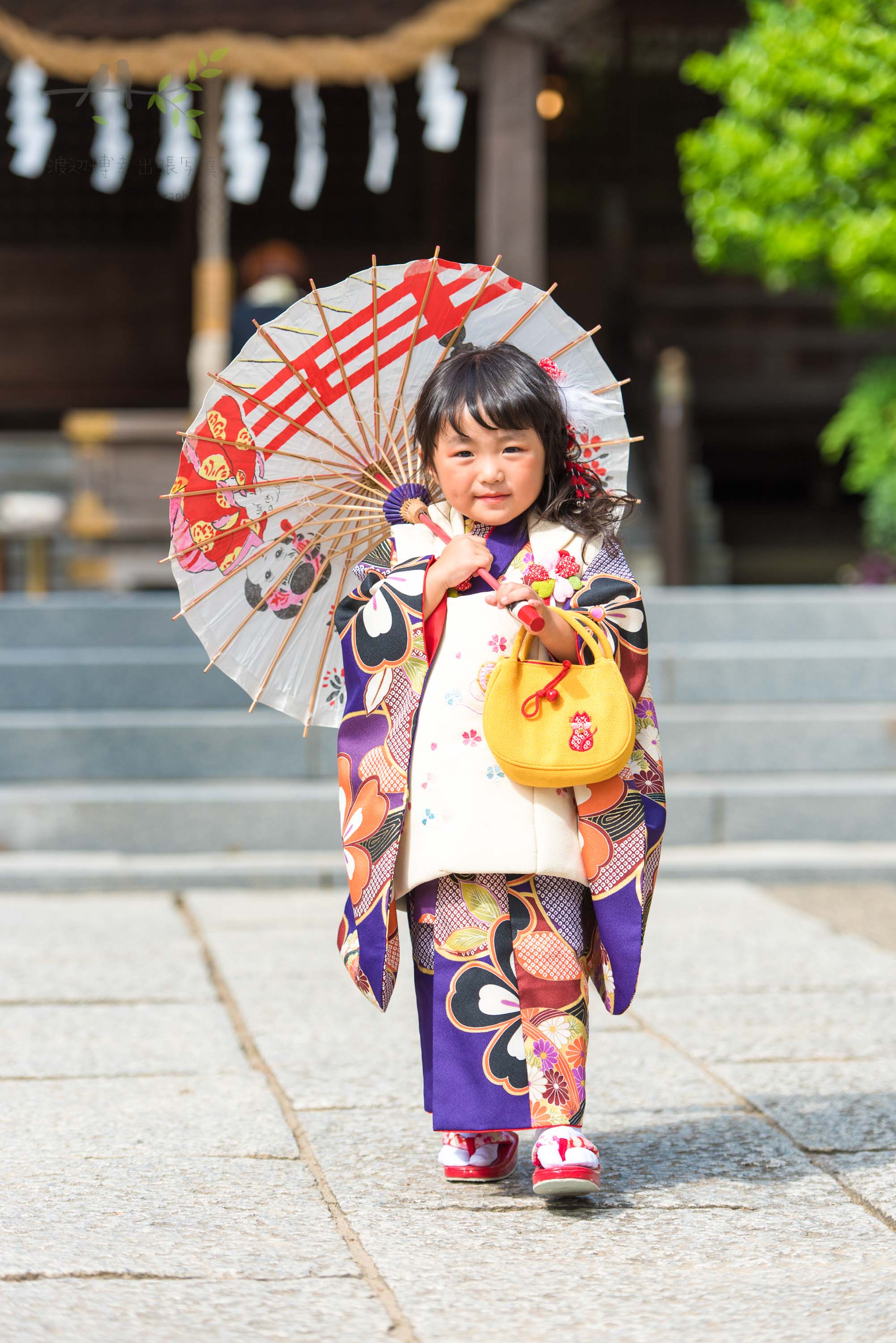 七五三の着物姿で和傘を指す小さな女の子