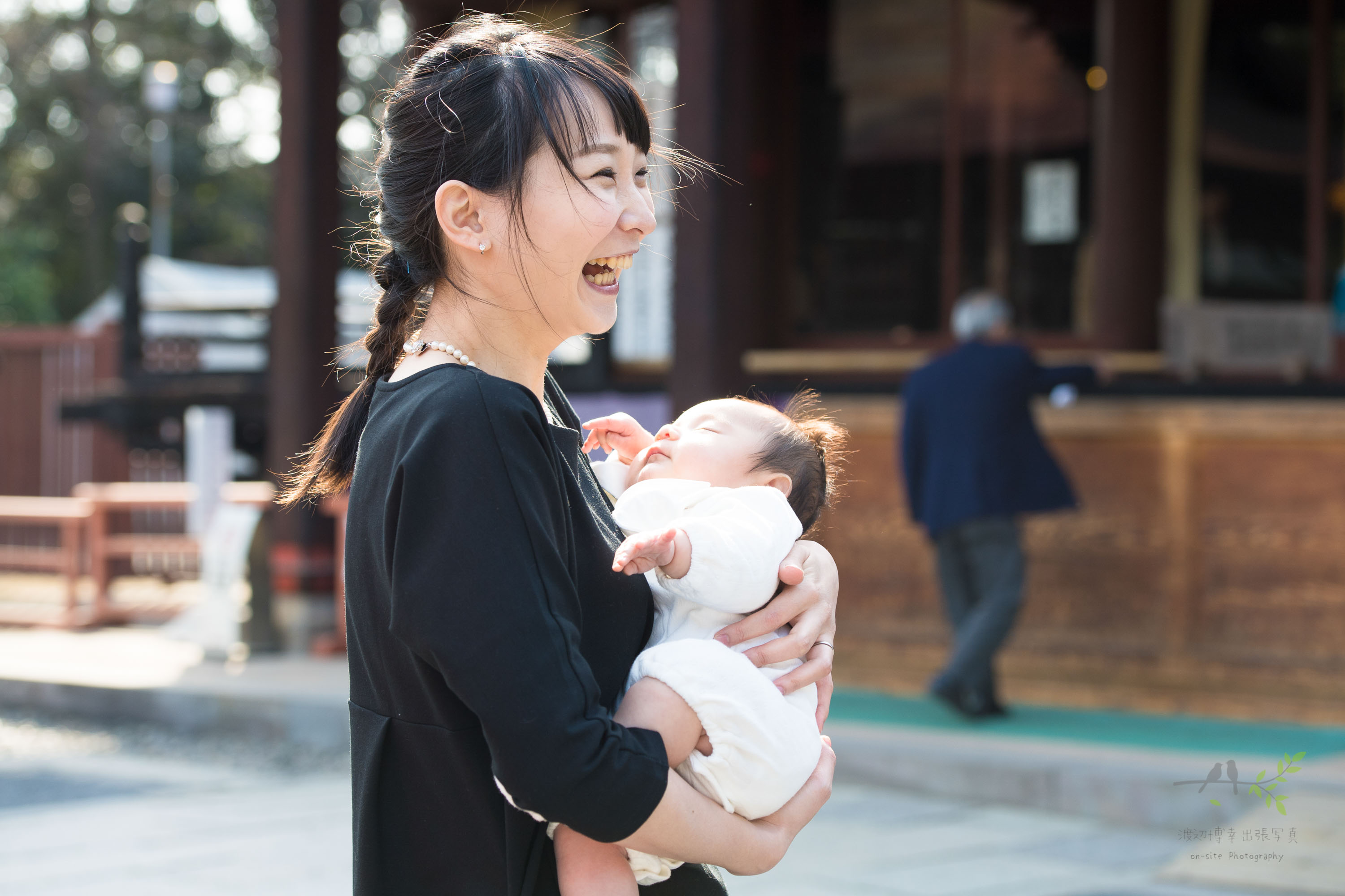 赤ちゃんを抱っこして笑う立ち姿の女性