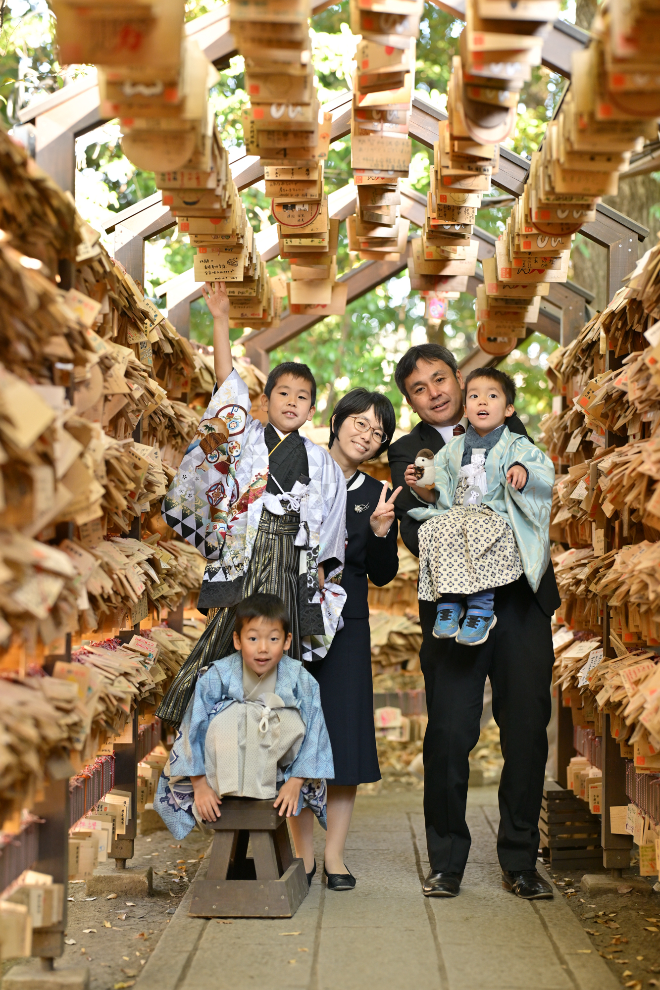 画像 川越氷川神社の絵馬トンネルを背景に、家族5人で寄り添って撮った七五三の記念写真