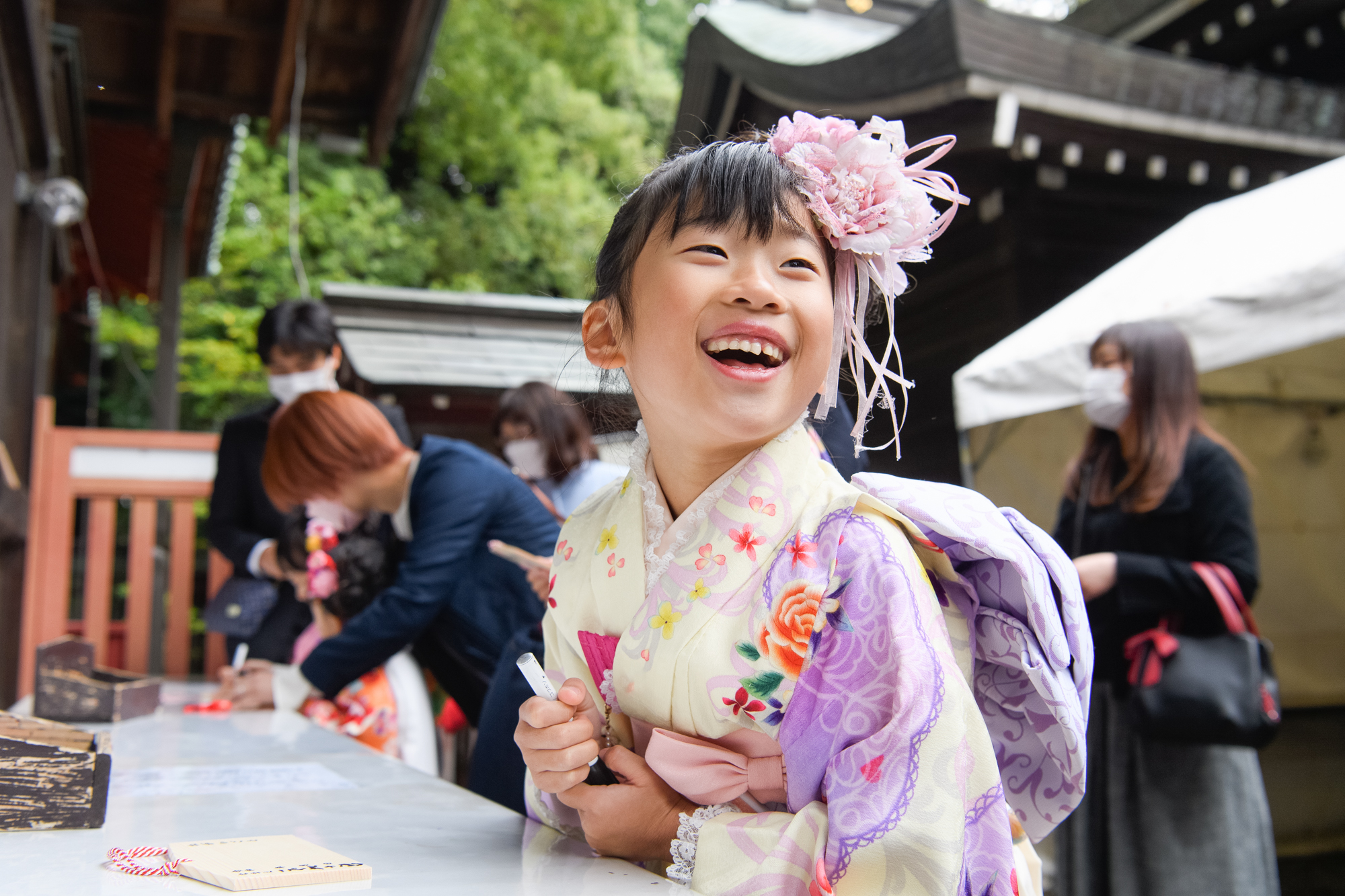 画像 川越氷川神社の境内で絵馬を書いている7歳の七五三の女の子