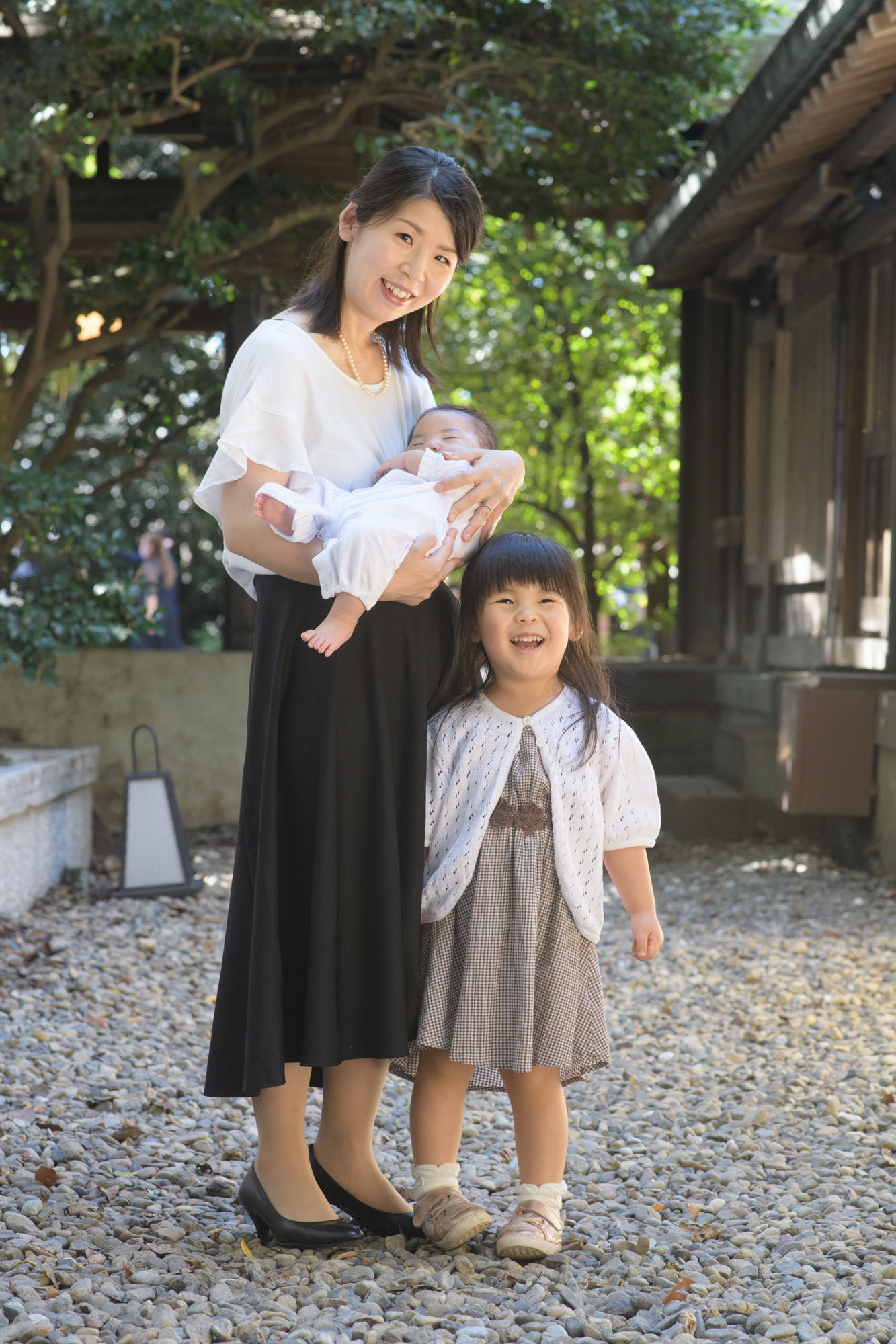 川越氷川神社のお宮参り、白いワンピースで赤ちゃんを抱っこする。ママと横に立つ上のお姉ちゃん