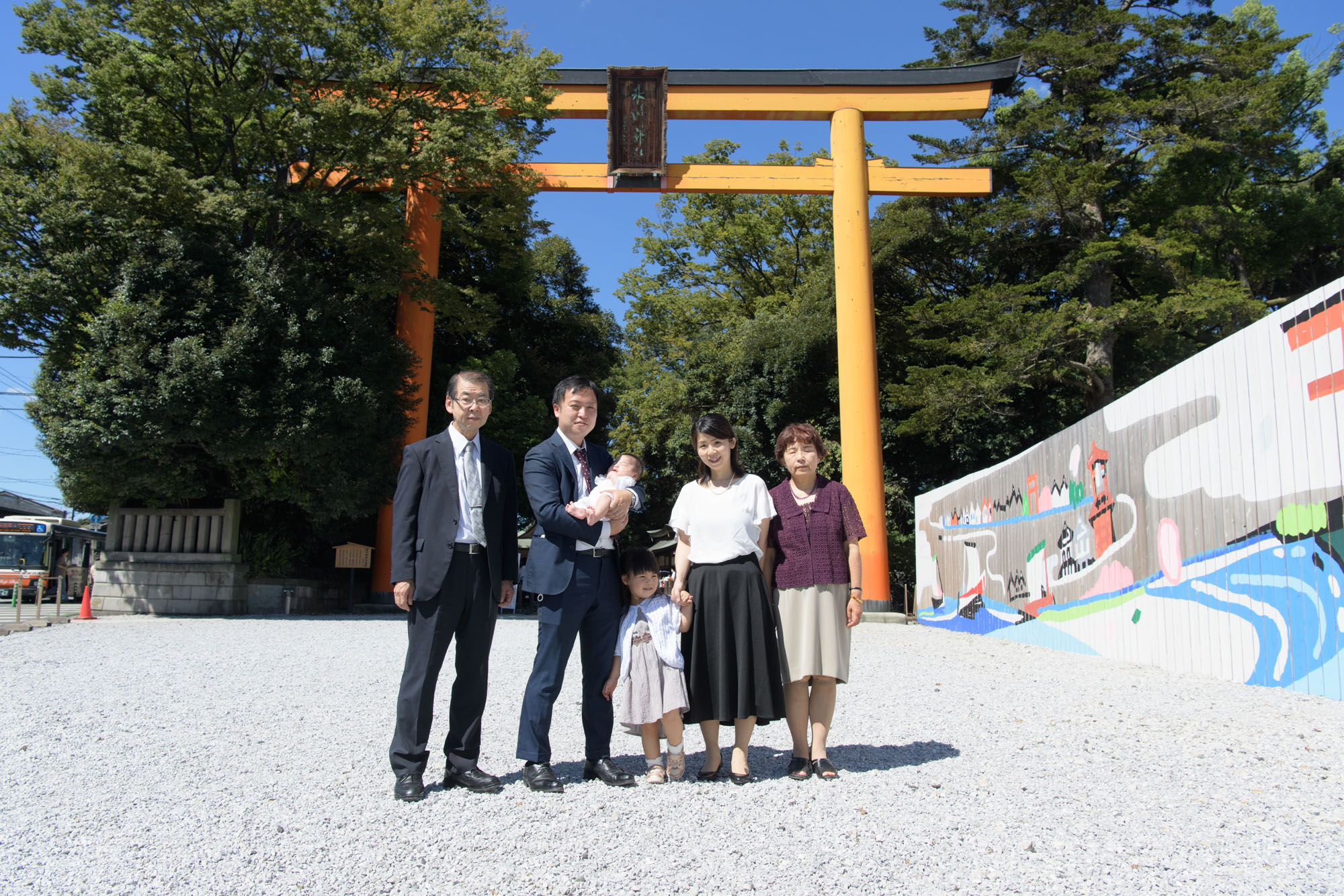 川越氷川神社のお宮参り、朱色の大鳥居の前で集合写真を撮る家族