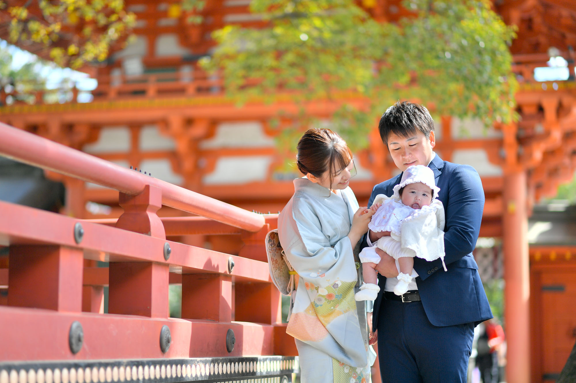 大宮氷川神社のお宮参りで、舞殿横で赤ちゃんを抱くご夫婦