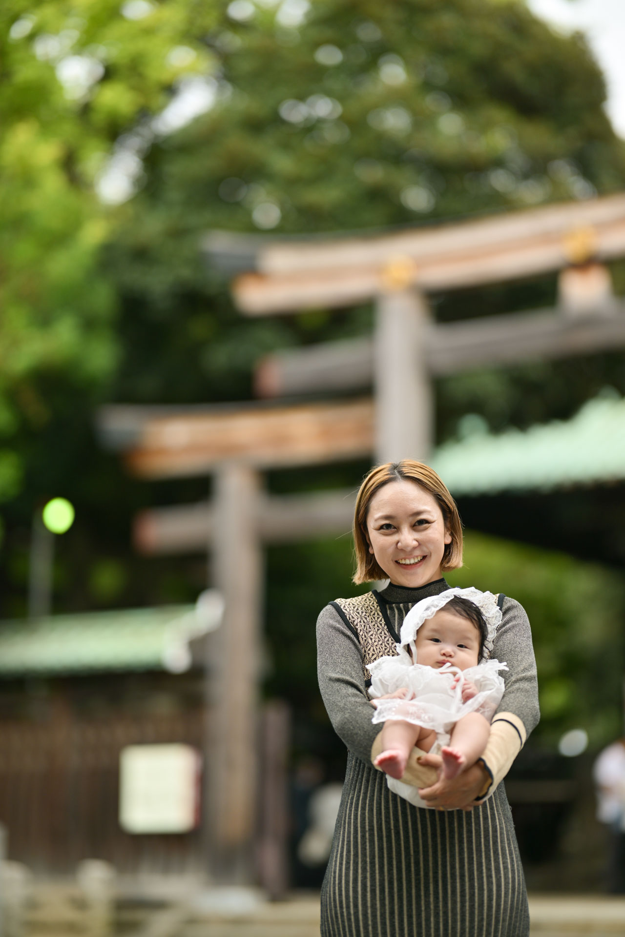 お宮参りで赤ちゃんを見つめる家族の写真
