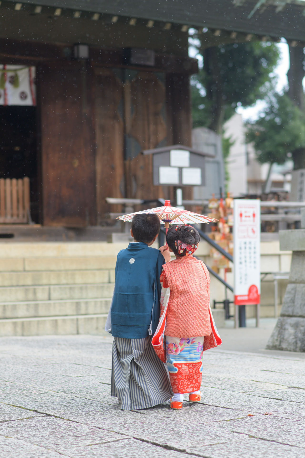 所澤神明社の七五三で、小さな和傘で相合い傘をする。5歳のお兄ちゃんと3歳の女の子。