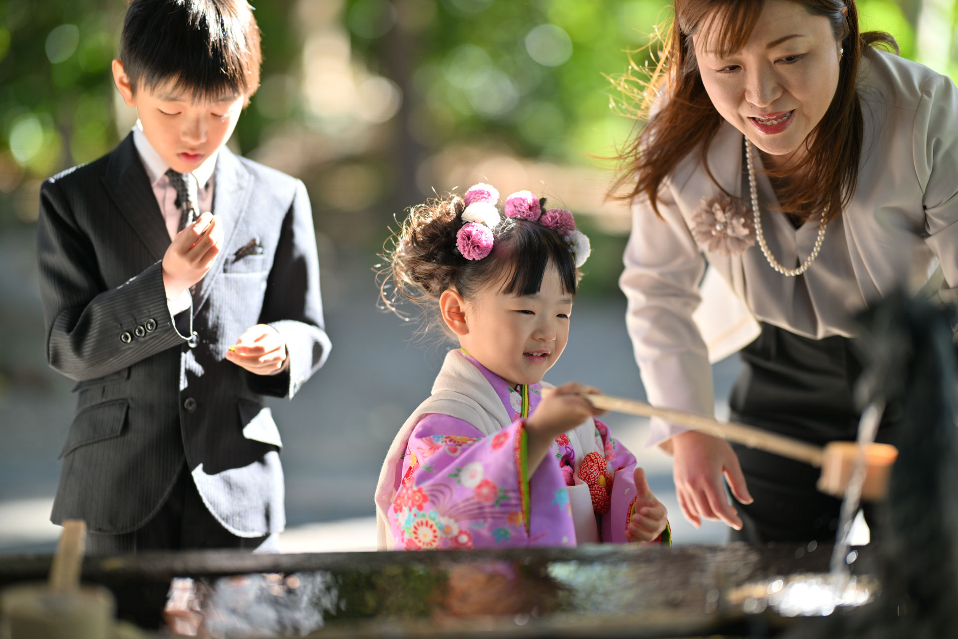 和楽備神社の手水舎で手を洗う七五三の女の子