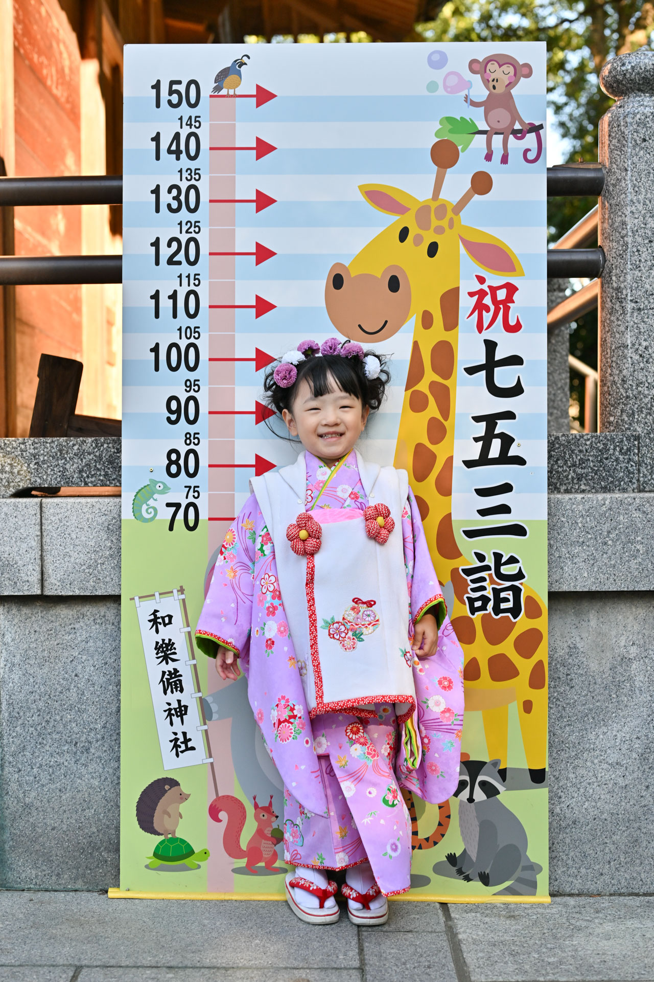 和楽備神社の七五三で身長を比べる看板前に立つ女の子